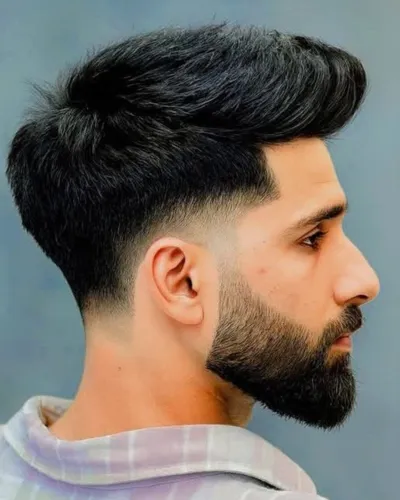 Best hairstyle for men with a diamond face shape featuring curtain bangs and a mid fade